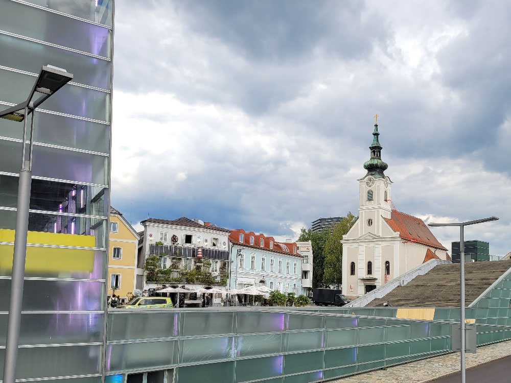 🚶‍♂️🚶‍♀️vorbei an der Ars Electronica, Stadtwerkstatt und der Kirche Grüner Anker (von links nach rechts)